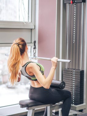 Genç kız spor salonunda egzersiz yapıyor.