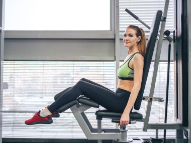 Genç kız spor salonunda egzersiz yapıyor.