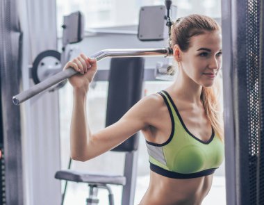 Genç kız spor salonunda egzersiz yapıyor.