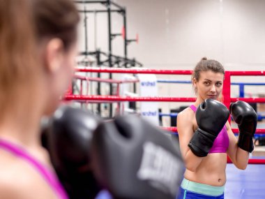 Genç model kız spor salonunda aynanın önünde egzersiz yapıyor. 