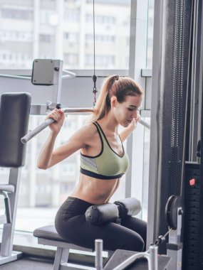 Genç kız spor salonunda egzersiz yapıyor.
