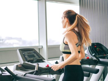 Genç kız spor salonunda egzersiz yapıyor.