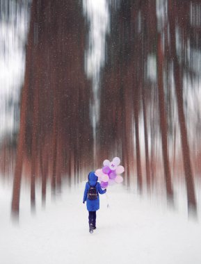 Ormanda balonlu mavi ceketli genç kız.