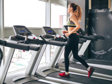 Genç kız spor salonunda egzersiz yapıyor.