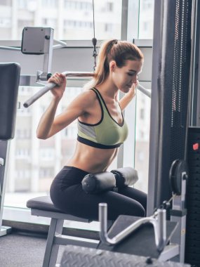 Genç kız spor salonunda egzersiz yapıyor.