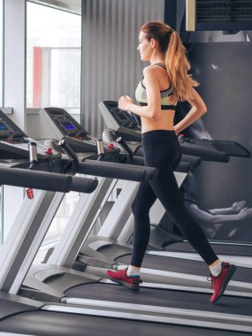 Genç kız spor salonunda egzersiz yapıyor.