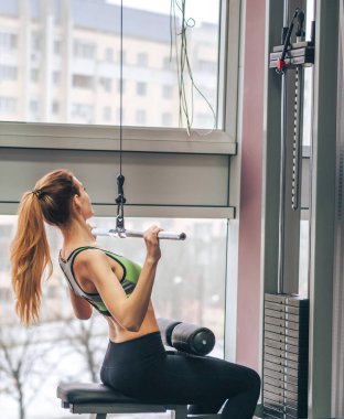 Genç kız spor salonunda egzersiz yapıyor.