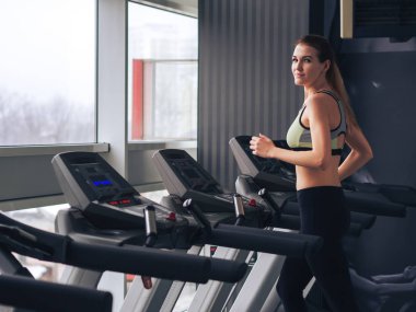 Genç kız spor salonunda egzersiz yapıyor.