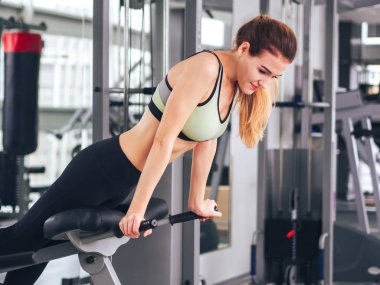 Genç kız spor salonunda egzersiz yapıyor.