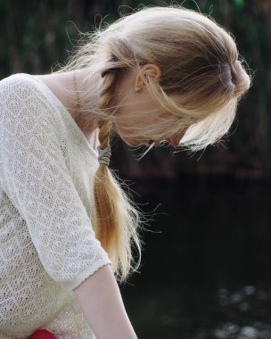 Göldeki genç kız aşağıya bakıyor.