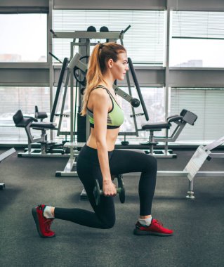 Genç kız spor salonunda egzersiz yapıyor.