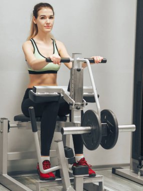 Genç kız spor salonunda egzersiz yapıyor.