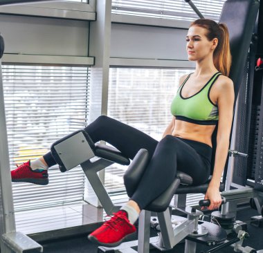 Genç kız spor salonunda egzersiz yapıyor.