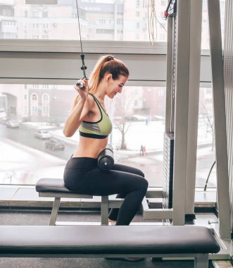Genç kız spor salonunda egzersiz yapıyor.