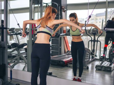 Genç kız spor salonunda egzersiz yapıyor.