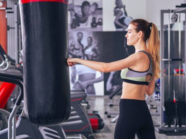 Genç kız spor salonunda egzersiz yapıyor.
