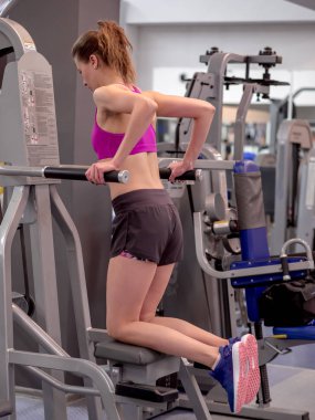 Genç model kız spor salonunda aynanın önünde egzersiz yapıyor. 