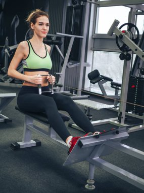 Genç kız spor salonunda egzersiz yapıyor.