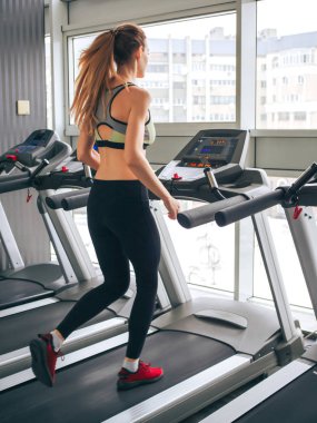 Genç kız spor salonunda egzersiz yapıyor.