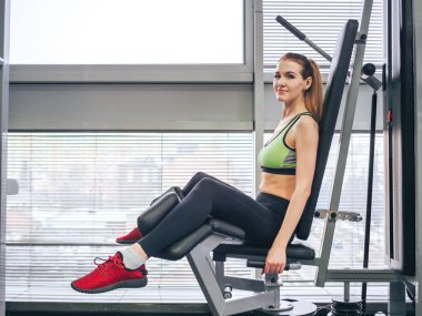 Genç kız spor salonunda egzersiz yapıyor.