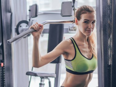 Genç kız spor salonunda egzersiz yapıyor.