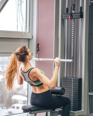 Genç kız spor salonunda egzersiz yapıyor.