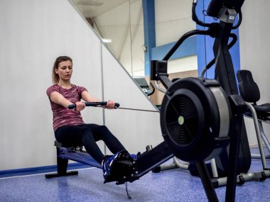 Genç model kız spor salonunda aynanın önünde egzersiz yapıyor. 