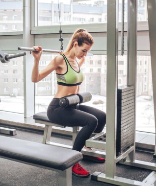 Genç kız spor salonunda egzersiz yapıyor.