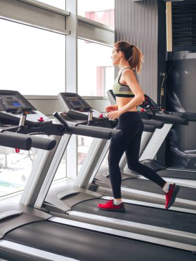 Genç kız spor salonunda egzersiz yapıyor.