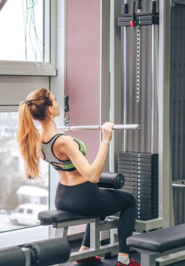 Genç kız spor salonunda egzersiz yapıyor.