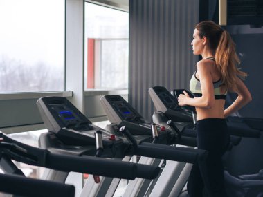 Genç kız spor salonunda egzersiz yapıyor.