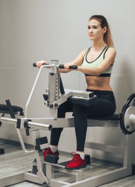 Genç kız spor salonunda egzersiz yapıyor.