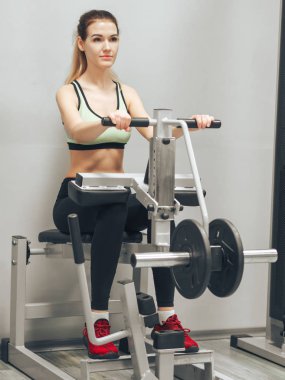 Genç kız spor salonunda egzersiz yapıyor.