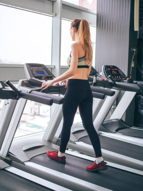 Genç kız spor salonunda egzersiz yapıyor.