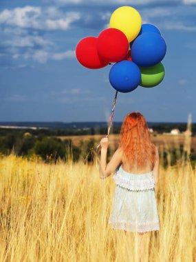 Sarı spikelets ve b ballons ile duran kız redhead