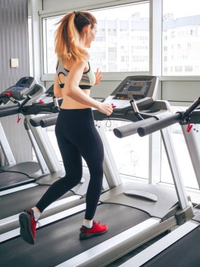 Genç kız spor salonunda egzersiz yapıyor.