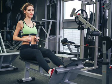 Genç kız spor salonunda egzersiz yapıyor.