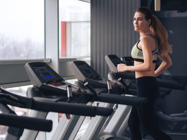 Genç kız spor salonunda egzersiz yapıyor.