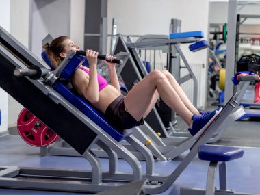 Genç model kız spor salonunda aynanın önünde egzersiz yapıyor. 