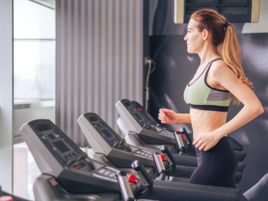 Genç kız spor salonunda egzersiz yapıyor.