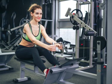 Genç kız spor salonunda egzersiz yapıyor.