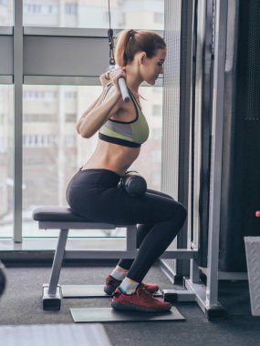 Genç kız spor salonunda egzersiz yapıyor.