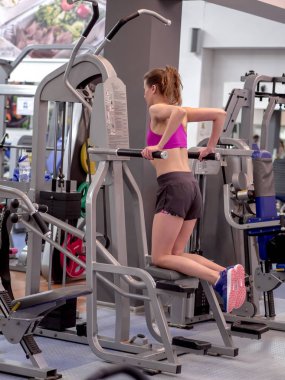 Genç model kız spor salonunda aynanın önünde egzersiz yapıyor. 