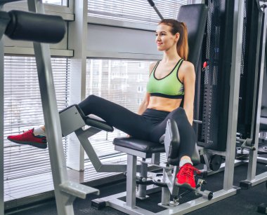 Genç kız spor salonunda egzersiz yapıyor.