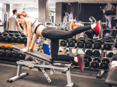 Genç kız spor salonunda egzersiz yapıyor.