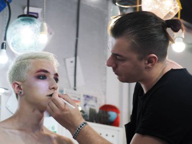 Makyaj sanatçı makyaj sarışın erkek modeli yakın çekim yapar