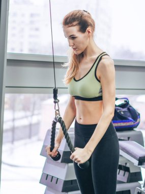 Genç kız spor salonunda egzersiz yapıyor.