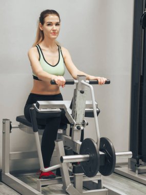 Genç kız spor salonunda egzersiz yapıyor.