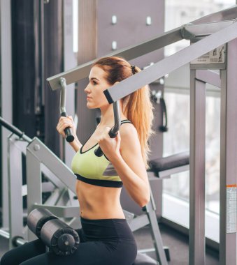 Genç kız spor salonunda egzersiz yapıyor.