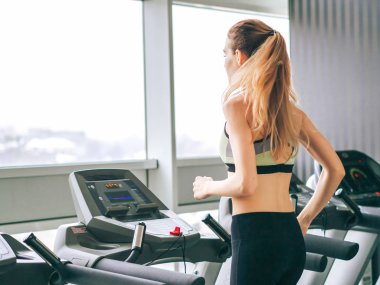 Genç kız spor salonunda egzersiz yapıyor.